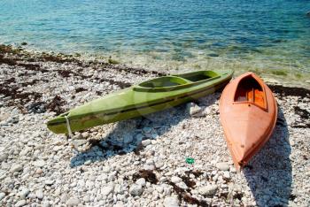 Two colour kayaks on the beach.