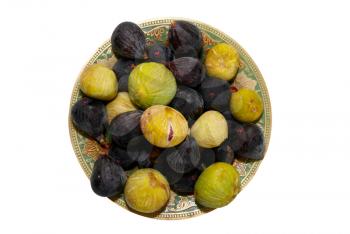 Stack of black and yellow figs on the plate isolated on white.