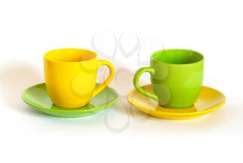Two colored tea cups and saucers on white background.