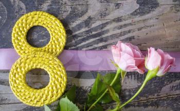 8 March symbol and roses. Figure of eight made of handmade buttons with roses on wooden background. Happy woman's day design. Can be used as a greeting card for international Woman's Day on 8 March.