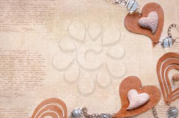 Light background with decoration of brown and beige hearts with beads on strings. Valentines Day hearts on vintage wooden background as Valentines Day symbol. love card design