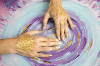 Two open empty Mehndi hands with palms down isolated on painted background. Gold pattern. Art therapy.
