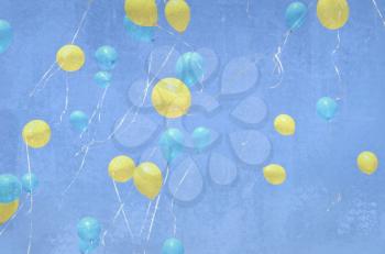 Many yellow and blue balloons flying up in the sky. Grunge background with balloons. Holiday event.