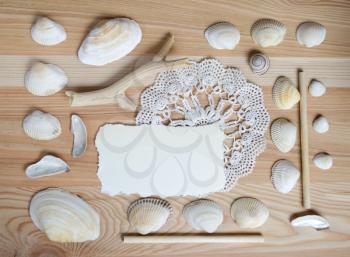 Seashells frame on wooden background with place for text. Card for a beach party, invitation, advertising. Summer holiday background.