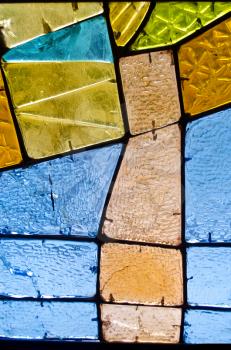 Abstract geometric colorful background. Image of a multicolored stained glass church window with irregular random block pattern, square format. Decorative window of various colored rectangles.