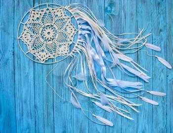 Dreamcatcher on a shabby blue wooden background. Ethnic design, boho style, tribal symbol.