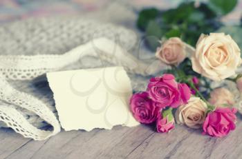 A bouquet of roses on a gray background of tender merino wool and wood. In the photo there is a place for a congratulatory text