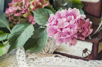 Still life of hydrangea, ancient mirror on knitted crocheted napkin. Vintage composition in the style of chebbishik.