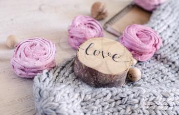 Homemade pink berry marshmallow. Composition with the inscription Love, wooden and knitted elements.