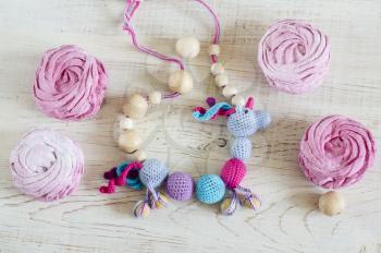 Homemade pink berry marshmallow. Necklace made from knitted beads for the baby sitting in a sling. Knitted unicorn. Sling necklace.