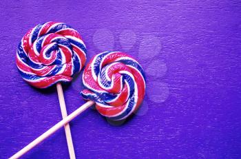 Lollipops on a stick on a violet background. A photo with a place for text
