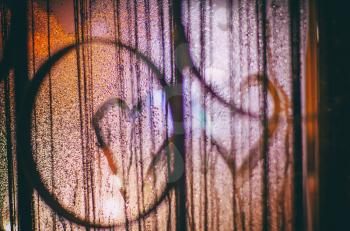 Photo of the heart on the misted window with light highlights. Art photo. Valentin day concept