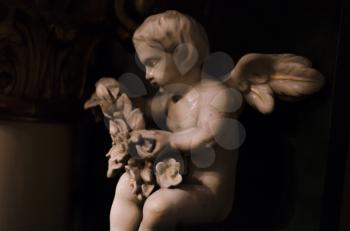 Angel medieval sculpture of white marble on a dark background.Figuur of the Catholic Church,