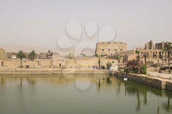 A pond near the ancient Egyptian buildings and ruins.