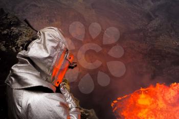 A man in a protective suit near the mouth of the volcano. Investigation of the volcano.