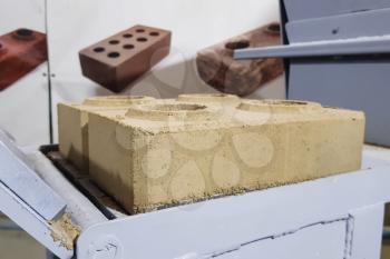 Brick making by hand pressing in a clamping mechanism.