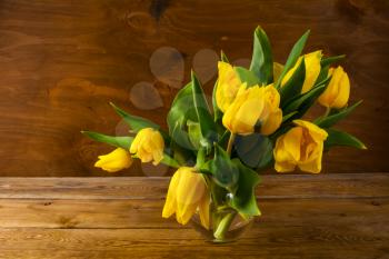 Spring yellow tulips bouquet on wooden background, copy space. Flowers greeting. Flowers postcard. Spring flowers