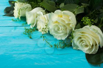 Spring summer fresh white ivory roses beautiful flowers on turquoise painted wooden planks. Mother's day greetings. Birthday congratulations. Selective focus. Сopy space. Postcard beautiful flowers
