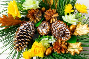 Christmas background with golden decorated pine cones and silk roses. Christmas party decoration, top view.