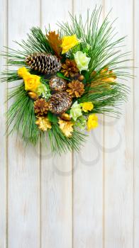 Christmas wreath with yellow fabric roses and golden pinecones. Christmas party decoration. Christmas greeting background. Copy space. 