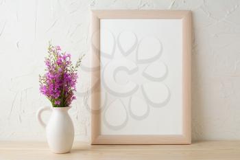 Frame mockup with purple wild flowers bouquet. Portrait white frame mockup. Empty white frame mockup for presentation artwork design.