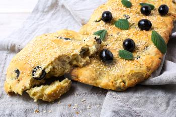 A piece of Italian bread Focaccia with olive and herbs. Homemade traditional Italian bread focaccia.