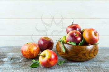 Apples in wooden bowl on the rustic background. Ripe  fruits as vegetarian food concept. Healthy eating concept with fresh fruits.