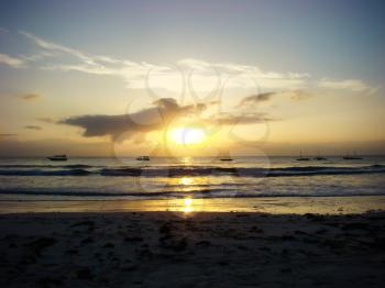 Sunrise on tropical sea sand beach, boats on skyline, Mombasa, Kenya                            