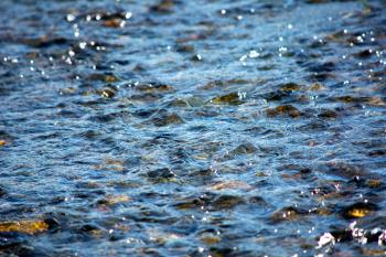 Ripples on the water of mountain river. Blue water surface texture background