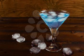 Blue iced margarita cocktail on rustic background. Blue margarita. Blue cosmopolitan. Blue Lagoon. Blue cocktail. Blue Martini. Blue Hawaiian cocktail. Blue curacao liqueur.