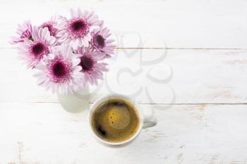 Coffee mug and lilac daisies, top view. Coffee cup. Strong coffee. Coffee mug. Morning coffee. Cup of coffee. Coffee break.