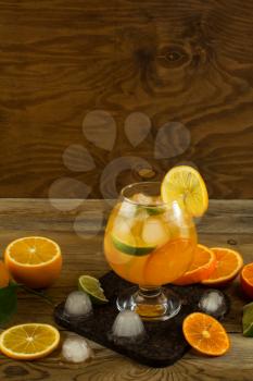 Cool fruit cocktail on wooden table, place for text. Fruit cocktail. Fruit drink. Citrus lemonade. Fruit lemonade. Summer drink 