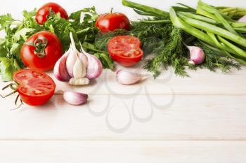 Garlic and tomato on the white wooden background. Vegetarian  vegan food. Healthy eating concept with fresh vegetables.