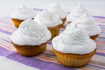 White cupcakes on the striped linen napkin. Birthday cupcakes. Homemade cupcake. Sweet cupcake. Gourmet cupcakes. Sweet pastry.  Sweet dessert.