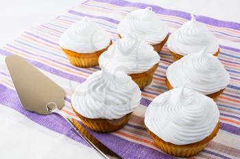 White cupcakes on the striped napkin. Birthday cupcakes. Homemade cupcake. Sweet cupcake. Gourmet cupcakes. Sweet pastry.  Sweet dessert.