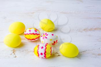 Decorated Easter white pink red yellow eggs on a white wooden background, space for text, copy space