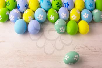 Pastel colored Easter eggs on a white wooden background, copy space