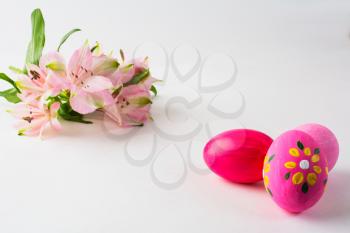 Pink Easter eggs with floral design and pink flowers on a white background. Easter background. Easter background. Easter symbol. Copy space