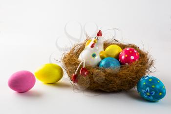 Porcelain Hen in a nest with painted Easter eggs on a white background. Close up. Easter background. Easter background. Easter symbol. Copy space
