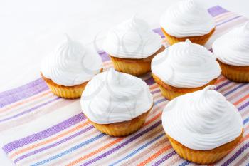 Cupcakes with white whipped cream swirl. Homemade cupcakes with whipped cream.  Homemade cupcakes served for party. 