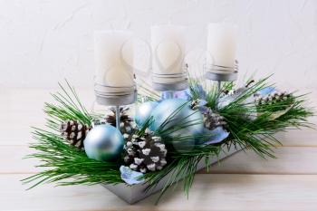 Christmas table centerpiece with candles and blue ornaments. Christmas decoration with blue balls. Christmas party background. 