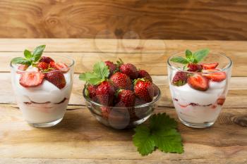 Cream dessert with strawberries on dark wooden background. Summer dessert with fresh ripe strawberry.