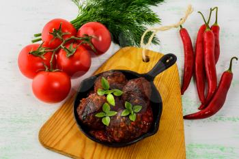 Grilled beef meatballs with chili pepper served in skillet. Grilled bbq meatloaf. Barbecue meatballs. 