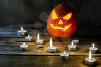Halloween jack-o-lantern and burning candles. Halloween symbol smiling pumpkin background. 