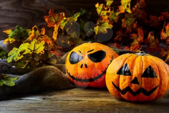 Halloween symbol smiling pumpkin on dark rustic background. Halloween jack-o-lantern and burning candles background. 