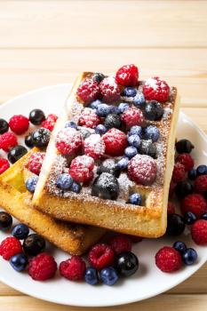 Homemade breakfast  Belgian waffles with blueberry and raspberry. Breakfast waffles with fresh berries.