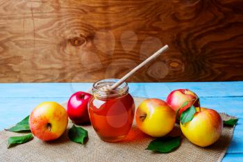 Honey glass jar and apples on rustic background copy space. Rosh hashanah concept. Jewesh new year symbols. 
