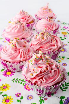 Pink birthday cupcakes  with whipped cream. Homemade cupcakes served for party. Birthday card background. 