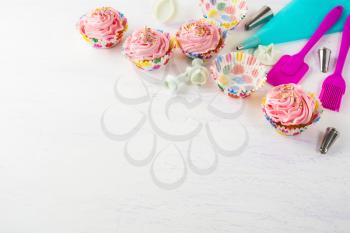 Pink cupcakes  and cookware invitation background. Birthday cupcakes. Birthday background. Homemade cupcake. Birthday mockup. 