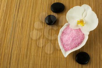 Spa concept with pink sea salt and spa stones.  Spa treatment concept. Wellness still life.
